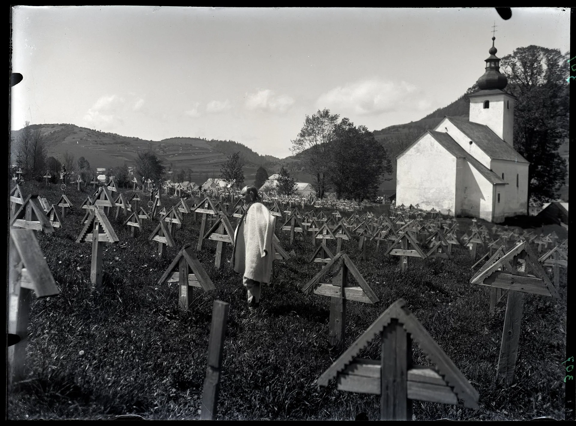 Obrázek Na hřbitově v Čičmanech. Starý Hamala, kolem dřevěné řezbované kříže z konce 19. stol.