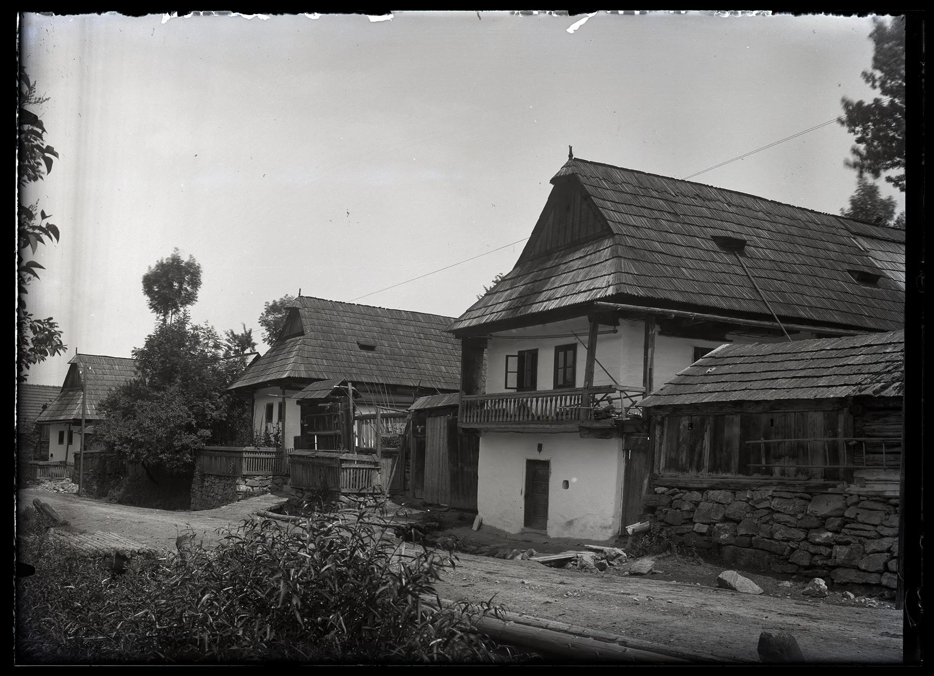 Obrázek Řada chalup při cestě, na kamenné podrovnávce, nadsklepní, pavlač, zvalbené, šindel, podlomenice